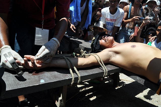 CRUCIFIXION. A penitent being nailed to the cross in Pampanga. File photo by LeAnne Jazul/Rappler 