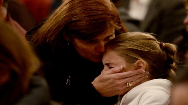 MOURNERS. Residents of Newtown gather at St Rose of Lima Church to remember those who died. AFP photo