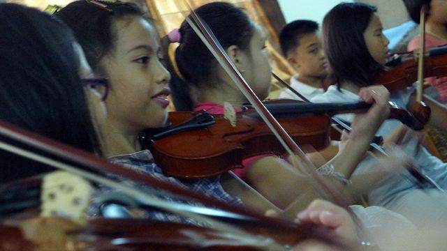 KWS STUDENTS LEARN HOW to play the violin. Photo by Ime Morales