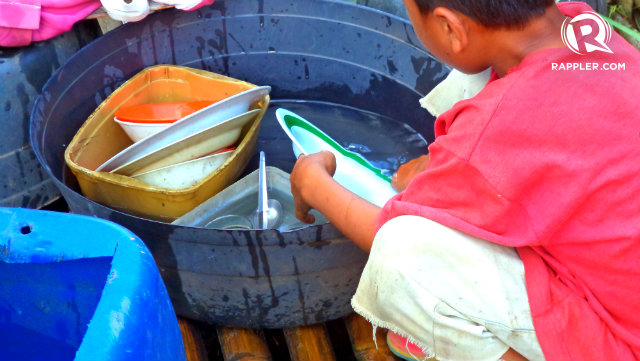 NO SINK, SOAP. A boy washes his family's dishes and utensils with nothing but water from an improvised well. Photo by Fritzie Rodriguez/Rappler.com