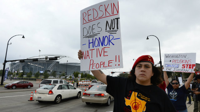 Protesters hold up signs in protest of the Washington Redskins name outside the stadium before the Dallas Cowboys game against the Washington Redskins this past October. Photo by Larry W. Smith/EPA