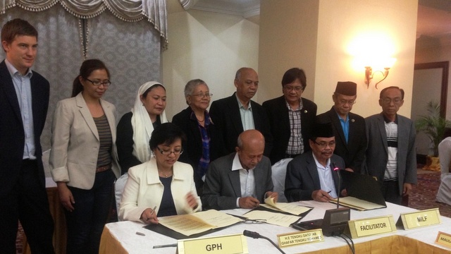 BREAKTHROUGH. Government peace panel chair Miriam Coronel-Ferrer, Malaysian facilitator Tengku Dato Ab Ghafar Tengku Mohamed and MILF peace panel chair Mohagher Iqbal sign the wealth-sharing annex and joint statement. Photo from OPAPP  