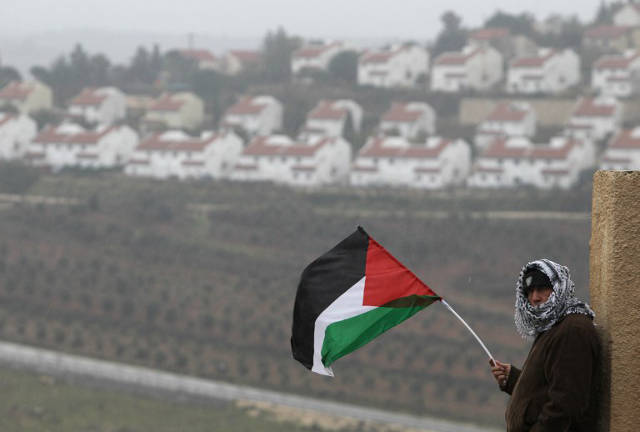 REJECTING PEACE TALKS. In this file photo, a Palestinian man waves his national flag on the sidelines of a march organized by inhabitants of the West Bank village Nabi Saleh on December 21, 2012, to protest against the expansion of Jewish settlements on Palestinian land. AFP/Abbas Momani