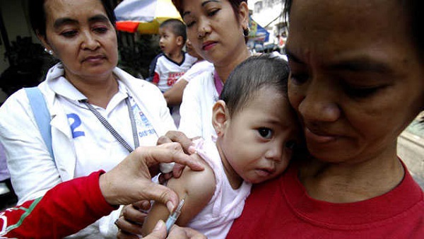 FREE VACCINE. A nurse injects an infant with a measles vaccine in Tondo, Manila. File photo by Noel Celis / AFP
