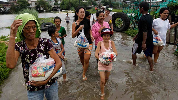RELIEF GOODS. Citizens bring goods they received back to their homes. Photo by EPA/Francis Malasig