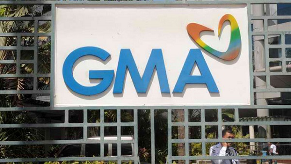 A security guard for local television network GMA talks on his mobile phone outside the company's offices in Manila on March 2, 2012. AFP PHOTO / JAY DIRECTO
