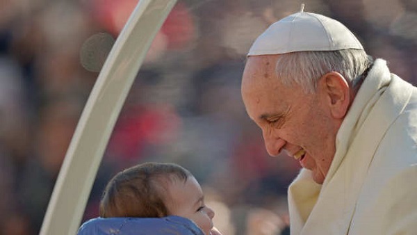 COMPASSIONATE PONTIFF. Pope Francis holds a baby as he arrives for his general audience at St Peter's Square on Dec 11, 2013 at the Vatican. Photo by Vincenzo Pinto/AFP