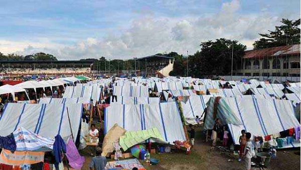 TENT COMMUNITY. Government tents in evacuation centers cannot withstand the heavy rain falling since October 4. File photo by Ted Aljibe/AFP