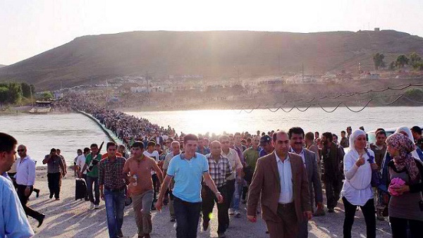 EXODUS. A handout photo obtained from the UNHCR on August 18, 2013 shows thousands of Syrians streaming across a bridge over the Tigris River and entering the autonomous Kurdish region of northern Iraq on August 15. Photo by AFP / UNHCR / Galiya Gubaeva