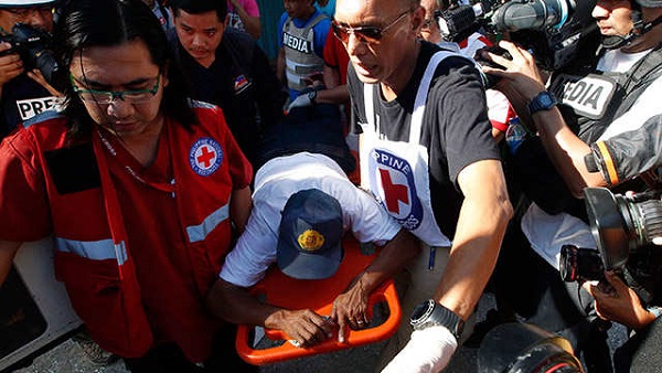 INJURED. In this file photo, Red Cross workers carry a wounded hostage who escaped on the 5th day of the standoff in Zamboanga City. Photo by Dennis Sabangan/EPA