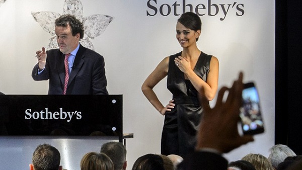 SWITZERLAND, Geneva : Chairman of auctioneers Sotheby's jewellery division in Europe and the Middle East, David Bennett (L), conducts the auction of the 