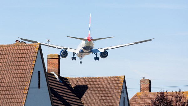 Plane over houses image from Shutterstock