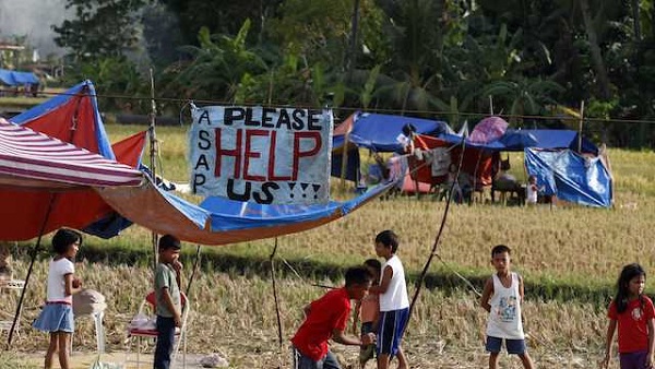 FOUR-LETTER WORD. A 'Help' sign is seen while Filipino children play outside their makeshift tents in rice fields drive following a 7.2-magnitude earthquake in Calape, Bohol, Philippines, 16 October 2013. EPA/Dennis Sabangan