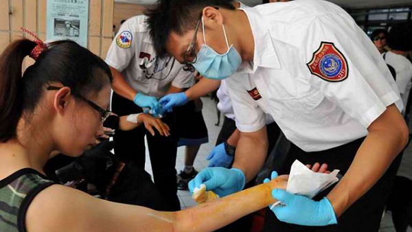 FIRST AID. Fire Department ambulance staff help a local resident who was bitten by her own pet cat while getting the rabies vaccine in New Taipei City on July 30, 2013. Photo by AFP / Mandy Cheng