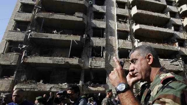 BLAST ZONE. A member of the Lebanese army talks on the phone at the site of a blast in Bir Hassan neighborhood in southern Beirut on November 19, 2013. AFP/Anwar Amro