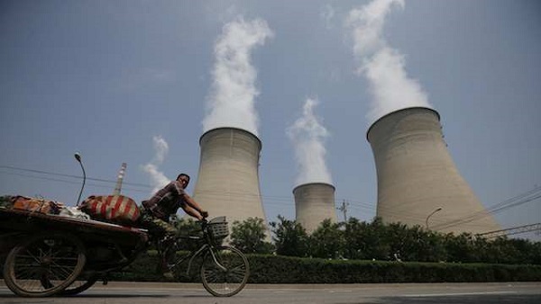 POLLUTED AIR. A man cycles past cooling towers in Beijing, China, 05 August 2013. EPA/Diego Azubel