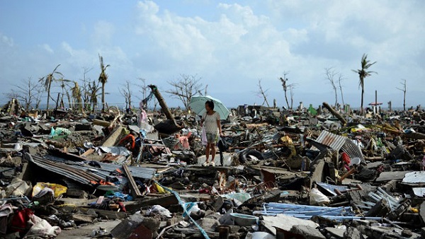PHILIPPINES, TACLOBAN : A surivor walks among the debris of houses destroyed by Super Typhoon Haiyan in Tacloban in the eastern Philippine island of Leyte on November 11, 2013. The United States, Australia and the United Nations mobilised emergency aid to the Philippines as the scale of the devastation unleashed by Super Typhoon Haiyan emerged on November 11. AFP PHOTO / NOEL CELIS