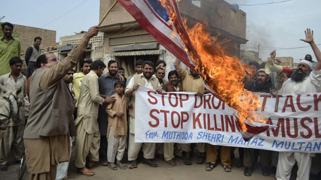 PAKISTAN, Multan : Activists of Pakistan Muthidda Shehri Mahaz burn the US flag during a protest in Multan on March 14, 2012, against US drone attacks. A US drone strike in Pakistan's lawless tribal belt on March 13 killed eight fighters supporting the Taliban in Afghanistan but not hostile to Pakistani authorities, local officials said. AFP PHOTO/S S MIRZA