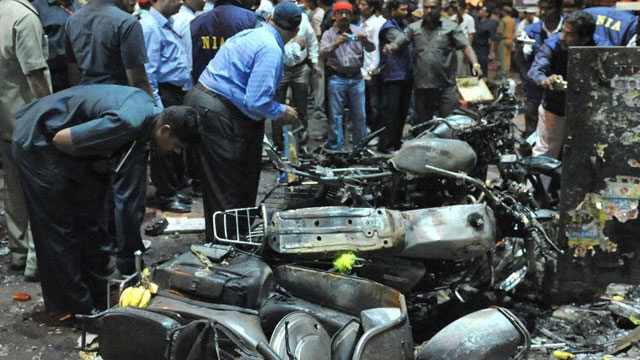 INDIA, Hyderabad : Indian police and investigators are pictured at the site of a bomb blast at Dilshuk Nagar in Hyderabad on February 21, 2013. At least 18 people were killed and 52 wounded when bombs ripped through crowded areas of the Indian city of Hyderabad on Thursday in what the prime minister called a 