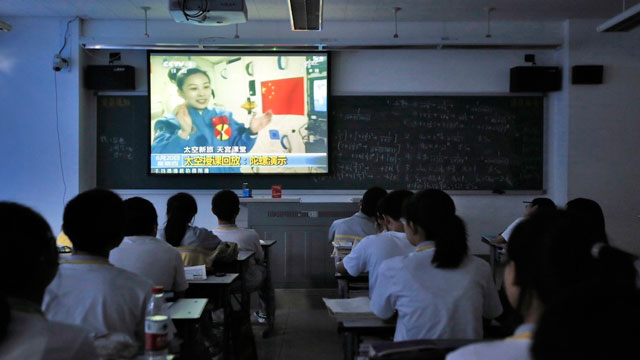 LESSON FROM SPACE. Students watch a lesson by Chinese astronaut Wang Yaping on a screen in their classroom in Beijing 2nd Middle School in Beijing, China, 20 June 2013. Photo by How Hwee Young/EPA