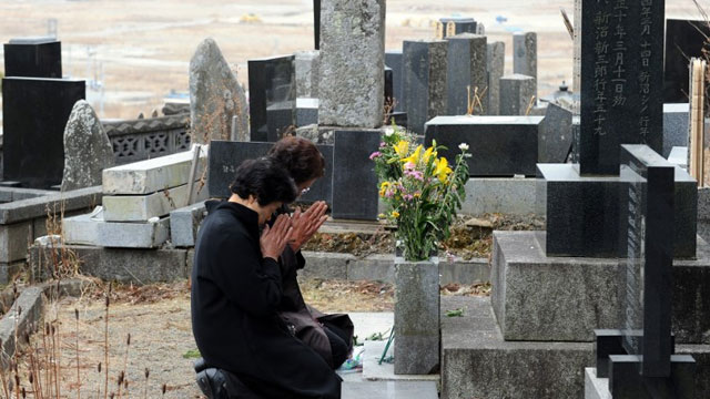 TWO YEARS. Sumiko Yoshida (R, w/glasses) and her sister Katsue Nagano (L) pray at the tomb during the prayers for five of their family members who were killed in the March 11, 2011 tsunami in Rikuzentakata city one day before the second anniversary of the March 11 earthquake and tsunami disasters, in Rikuzentakata on March 10, 2013. AFP PHOTO / TOSHIFUMI KITAMURA