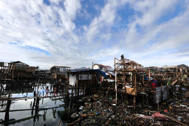 NEEDING HELP. Filipino children walk on wooden path on its way to their makeshift house in the typhoon devastated city of Tacloban, Leyte on December 24, 2013. File photo by Dennis Sabangan/EPA