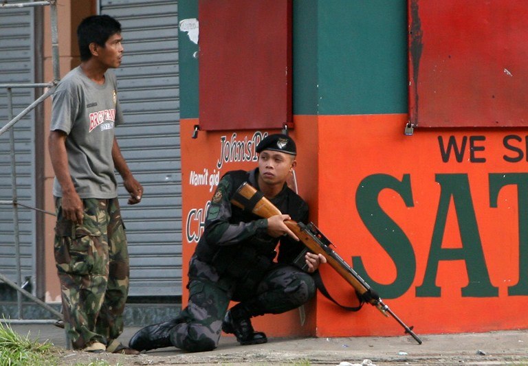CRISIS. A combat police force sniper gets into position in this photo taken Monday, Sept 9, 2013 in Zamboanga City. Photo by AFP/Stringer