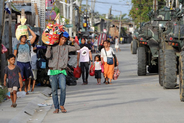 CROSSFIRE. Human rights of civilians have become a casualty in the fightings between government troops and MNLF rebels in Zamboanga City. File photo by Agence France-Presse