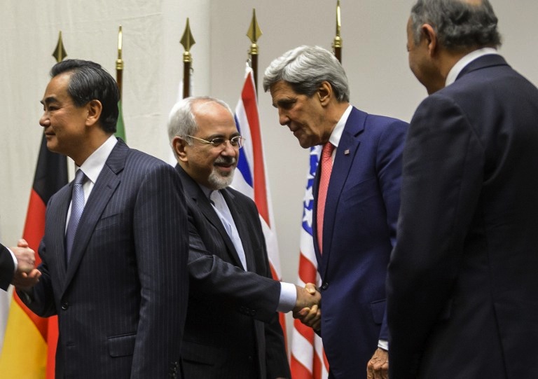 HISTORIC HANDSHAKE. Iranian Foreign Minister Mohammad Javad Zarif (2nd L) shakes hands with US Secretary of State John Kerry next to Chinese Foreign Minister Wang Yi (far L) and French Foreign Minister Laurent Fabius (far R) after a statement on early November 24, 2013 in Geneva. AFP/Fabrice Coffrini