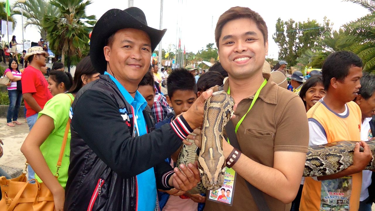 NOT JUST THE ZIPLINE. Writer Jerald Uy (right) holding the Ilagan Sanctuary python