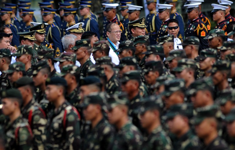 Philippine President Benigno Aquino (C) walks near troops during the Armed Forces of The Philippines (AFP) 78th Anniversary at the AFP headquarters in Manila on December 20, 2013. AFP PHOTO/NOEL CELIS