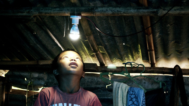 FINALLY, POWER. A boy looks up at a lightbulb powered by a solar panel installed in his home in Tanauan, Leyte. Photo by Nim Gonzales