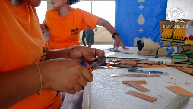 WOMEN IN ORANGE. An inmate of the Correctional Institute for Women in Mandaluyong cuts metal frames for solar panels intended for Yolanda-hit communities