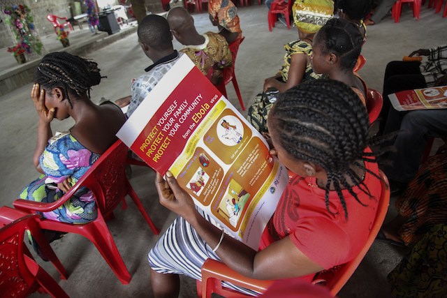INFO DRIVE. A Liberian woman reads an Ebola information poster on the prevention of the Ebola epidemic, during UNICEF's sensitization campaign at the Mission for Today Holy Church, in Newkru Town, Monrovia, Liberia, 22 June 2014. Ahmed Jallanzo/EPA