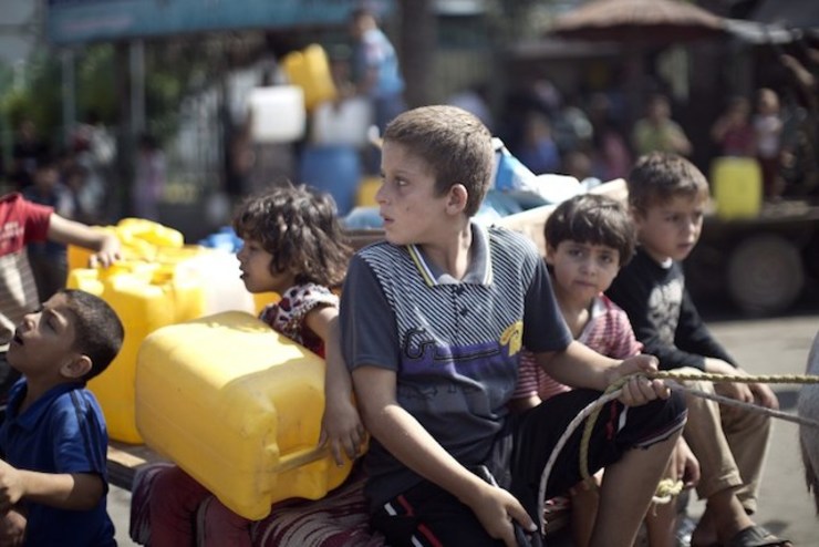 AMID THE LULL. Palestinians children wait to fill plastic bottles and water containers with drinking water from a public tap in Jabalia in the northern Gaza Strip on July 27, 2014. Mahmud Hams/AFP