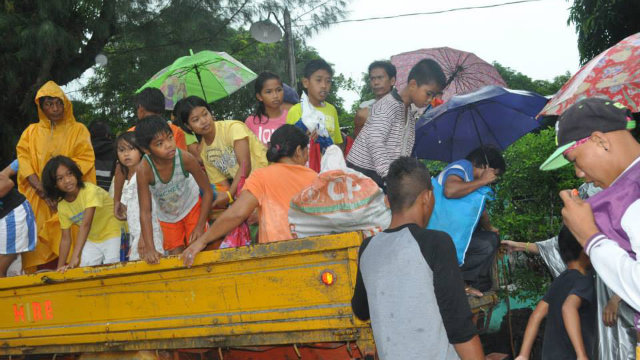 HEAVY LOAD. Evacuees in Albay board a truck while rain pours. Photo by Othelo Orpiada Padre