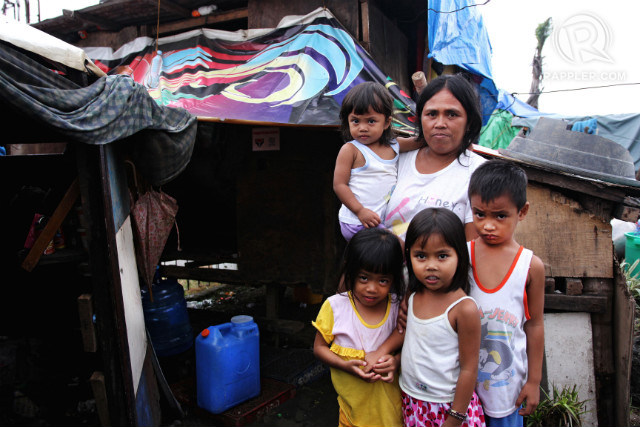 TILL WHEN? Rina Etang, 39, waits for the government to move her, along with her children and other relatives, to a bunkhouse unit. She lives in the shanty right behind her. Photo by Franz Lopez/Rappler