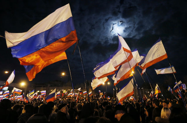 CRIMEA. People hold Russian flags as they gather at Lenin Square after the end of the referendum in Simferopol, Crimea, Ukraine, March 16, 2014. Photo by Yuri Kochetkov/EPA