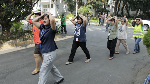 EARTHQUAKE DRILL. Employees of the Office of Civil Defense simulate an evacuation.  Photo from the OCD