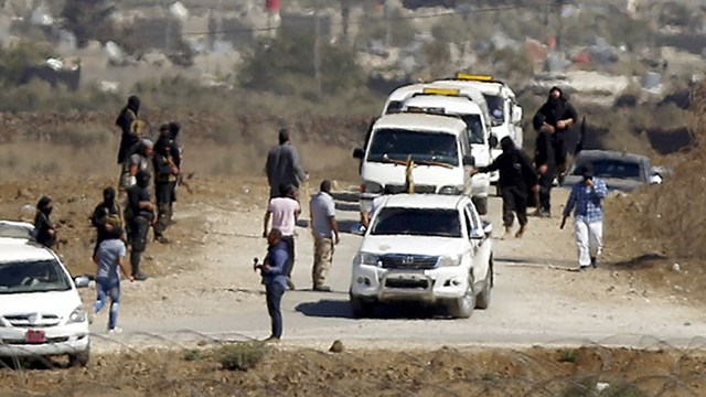 QATAR-FUNDED RANSOM? Members of al-Qaeda-linked fighters in Syria gather as vehicles carrying a group of Fijian peacekeepers arrive before the release on September 11. File photo by Jalaa Marey/AFP 