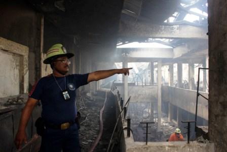 PASAR KLEWER. Seorang petugas pemadam kebakaran sedang memandu pekerja lainnya untuk membersihkan puing-puing kebakaran di Pasar Klewer Solo, Selasa, 30 Desember 2014/Rappler