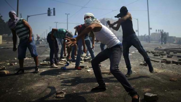 CLASHES. Masked Palestinian protesters throw stones towards Israeli police (unseen) during clashes in the Shuafat neighborhood in Israeli-annexed Arab East Jerusalem, on July 3, 2014, one day after a Palestinian teenager was kidnapped and killed in an apparent act of revenge for the murder by militants of 3 Israeli youths. Photo by AFP/Thomas Coex
