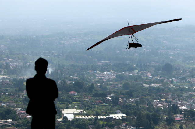 PUNCAK PASS. A hang glider flying over the resort town of Puncak near Jakarta, Indonesia. Photo by Adi Weda/EPA