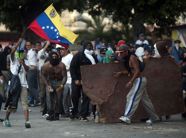VIOLENCE. A demonstrator holds a stone to throw at riot policemen during an anti-government protest in Caracas on February 22, 2014. File photo by Raul Arboleda/AFP